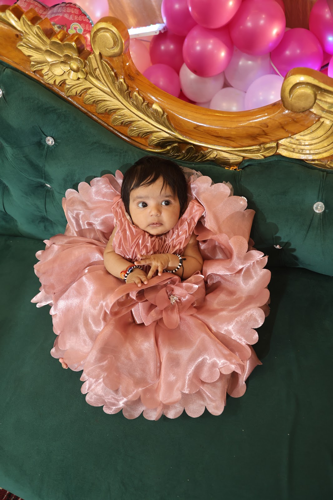 Baby girl in a pink dress photographed in studio