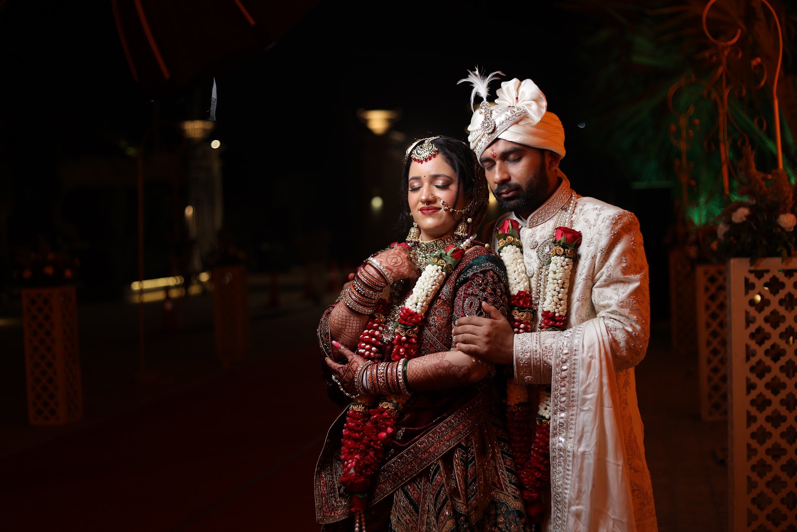 Bride and groom photographed at night in traditional wedding wear