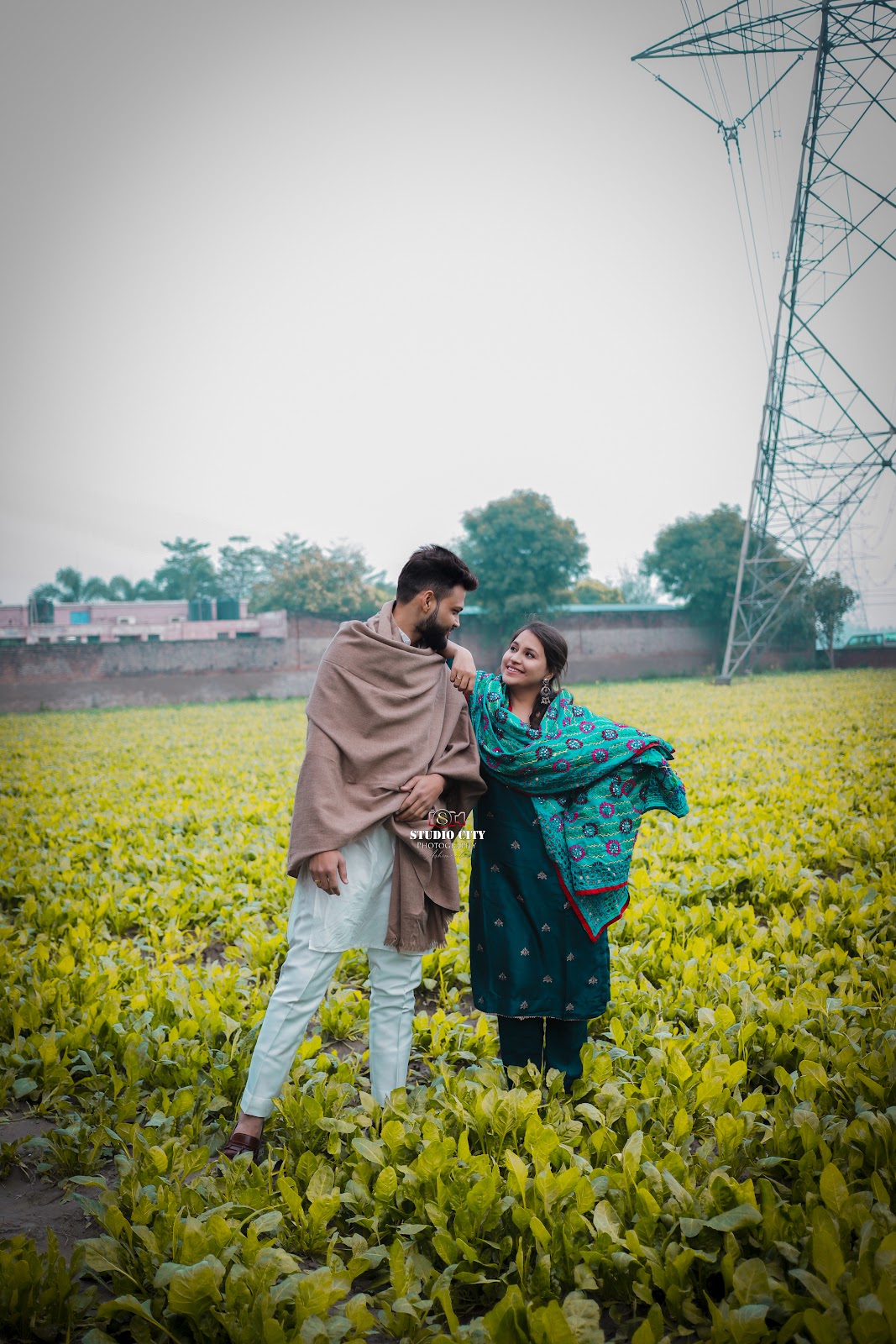 Couple walking through a mustard field at golden hour